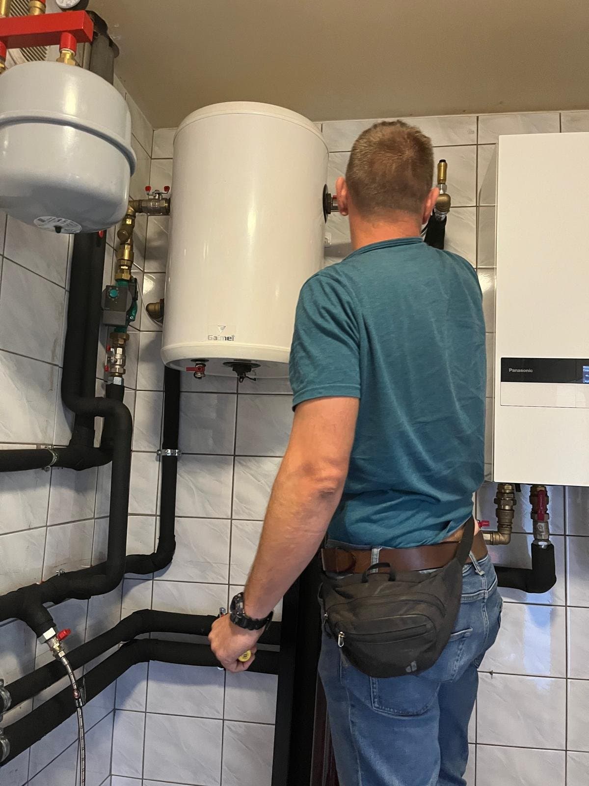 Robert Poczaj w kotłowni klienta Only-Yes — kompletna instalacja pompy ciepła Panasonic Aquarea z zasobnikiem CWU i izolowaną hydrauliką